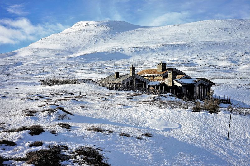 Bilde av privat hytte på Høgevarde med fjelltoppen i bakgrunn