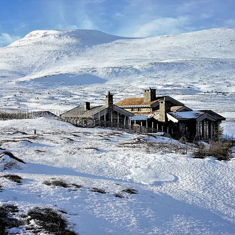 Bilde av privat hytte på Høgevarde med fjelltoppen i bakgrunn